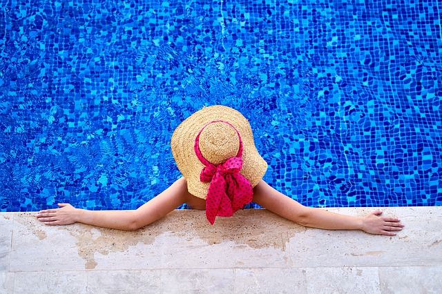 Eine Frau mit Hut steht in einem Pool