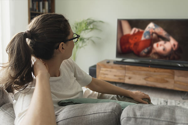 Eine Frau sieht sich Bilder auf einem Fernseher an